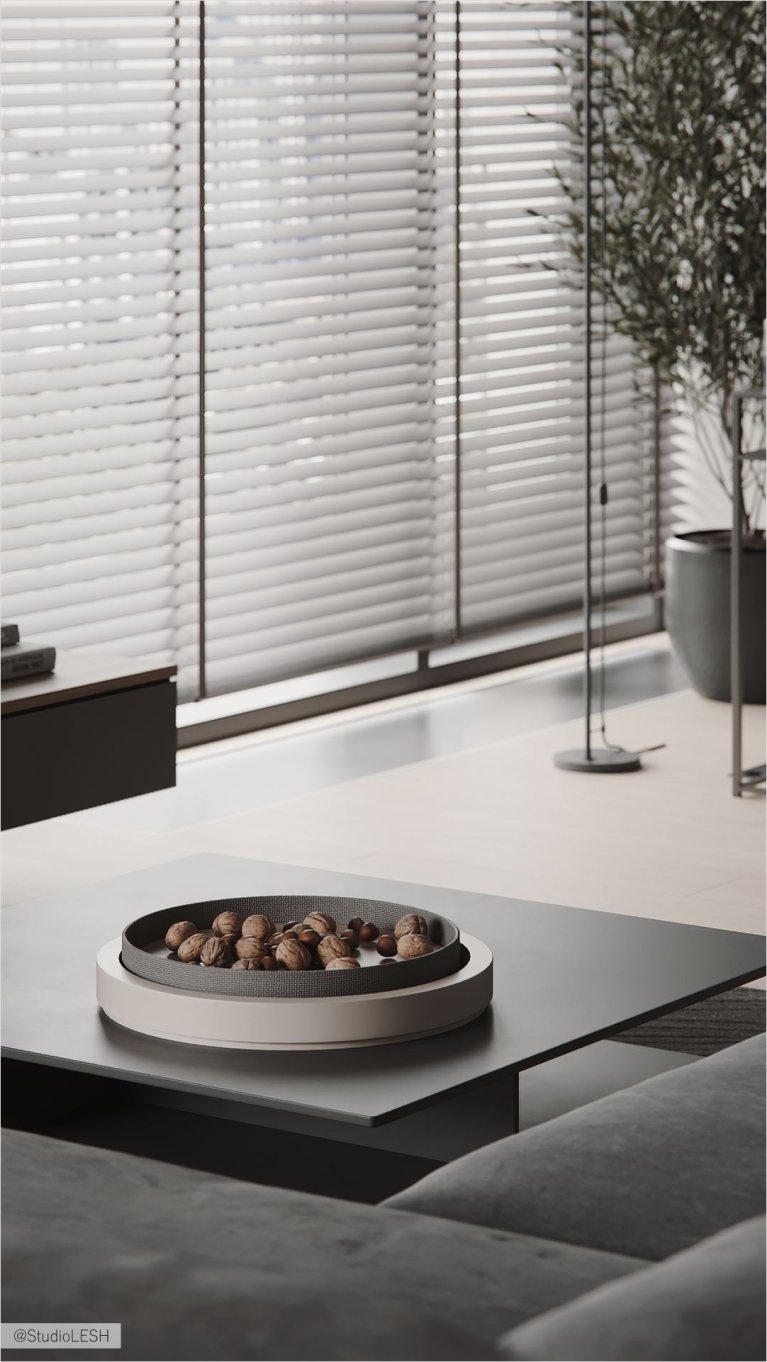 Современный журнальный столик с декоративной чашей с орехами в гостиной с жалюзи на окнах и оливковым деревом.