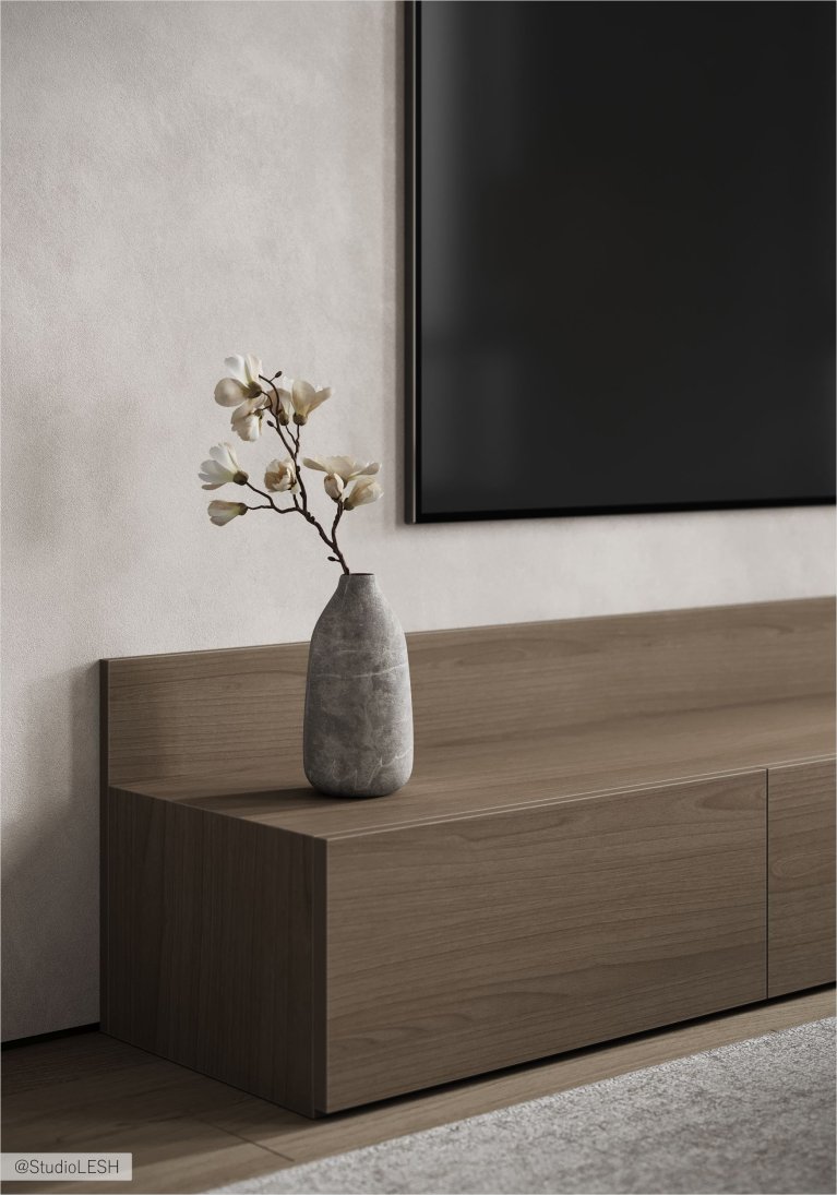 В гостиной на длинной деревянной тумбе под телевизор стоит серая ваза с белыми цветами.