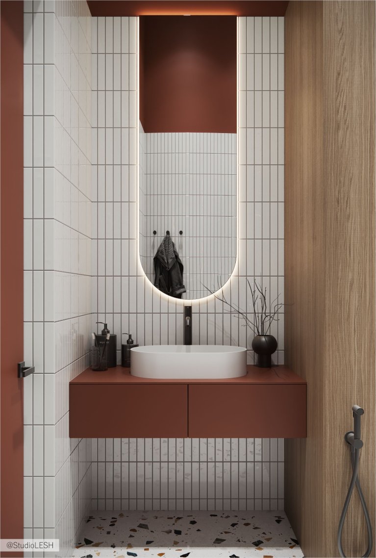 Интерьер современной ванной комнаты с белой раковиной, подвесной тумбой из дерева, зеркалом с подсветкой и отделкой плиткой под кирпич.