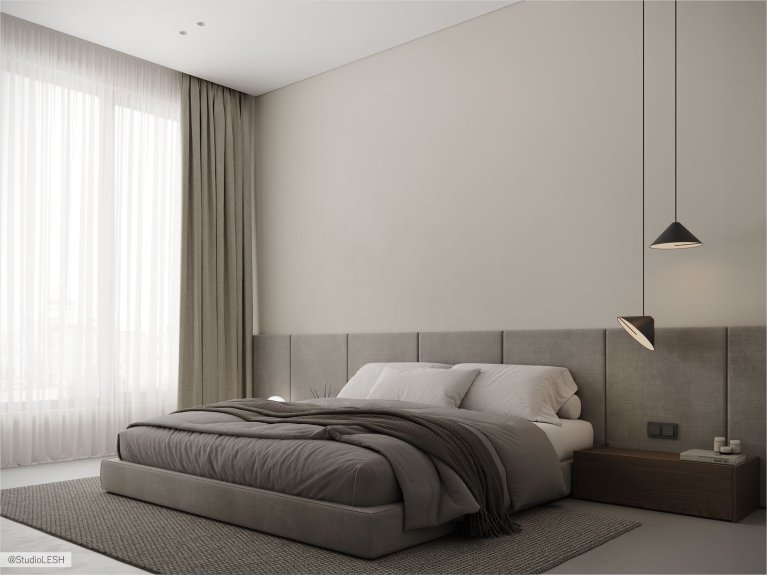 Интерьер современной комнаты с деревянным туалетным столиком, зеркалом необычной формы, мягким пуфом и картиной на стене.