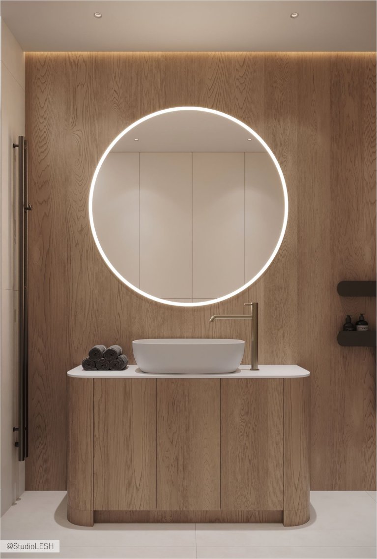Интерьер ванной комнаты с акцентом на натуральные материалы. Деревянные панели на стенах контрастируют с белой сантехникой и создают ощущение гармонии с природой. Овальное зеркало с подсветкой добавляет современности и функциональности