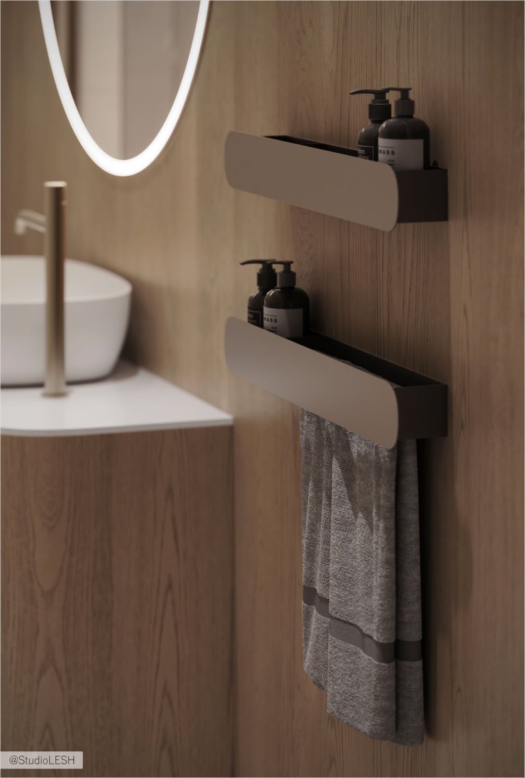 Ванная комната с двумя подвесными полками, на которых стоят серые бутылочки с дозаторами. На нижней полке также висит серое полотенце. В углу виден край овального зеркала с подсветкой и часть раковины. Стены отделаны деревянными панелями