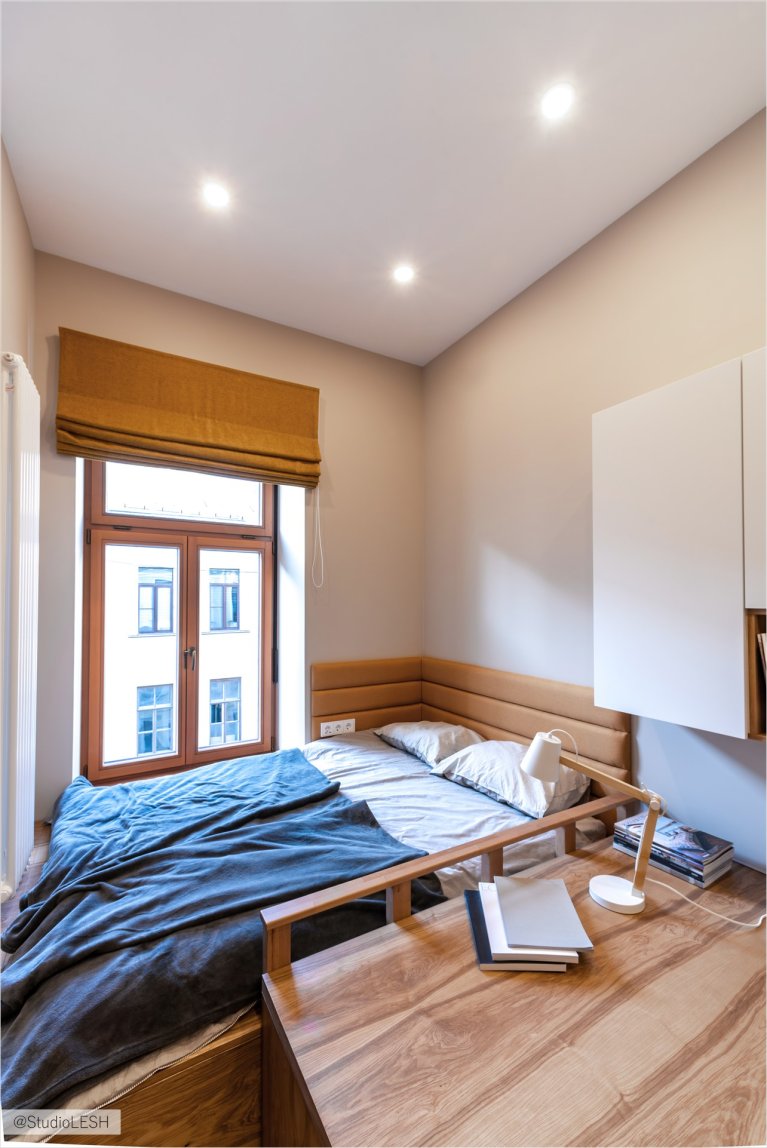 Дизайн современной спальни с деревянной мебелью: стильный интерьер с кроватью, рабочим столом и окном с римской шторой