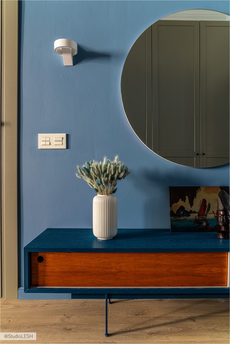 Тумба с выдвижными ящиками, украшенная вазой с сухоцветами, картиной и статуэткой