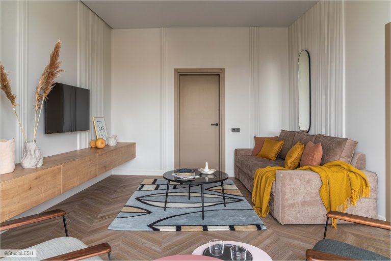 Уютная гостиная с мягкой мебелью, оригинальным декором и паркетным полом "елочкой"